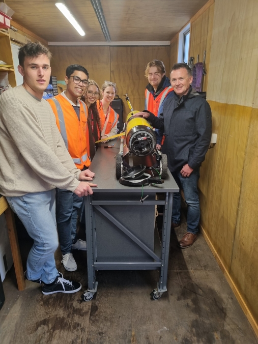 Joint grad school students with underwater research glider, Manaia